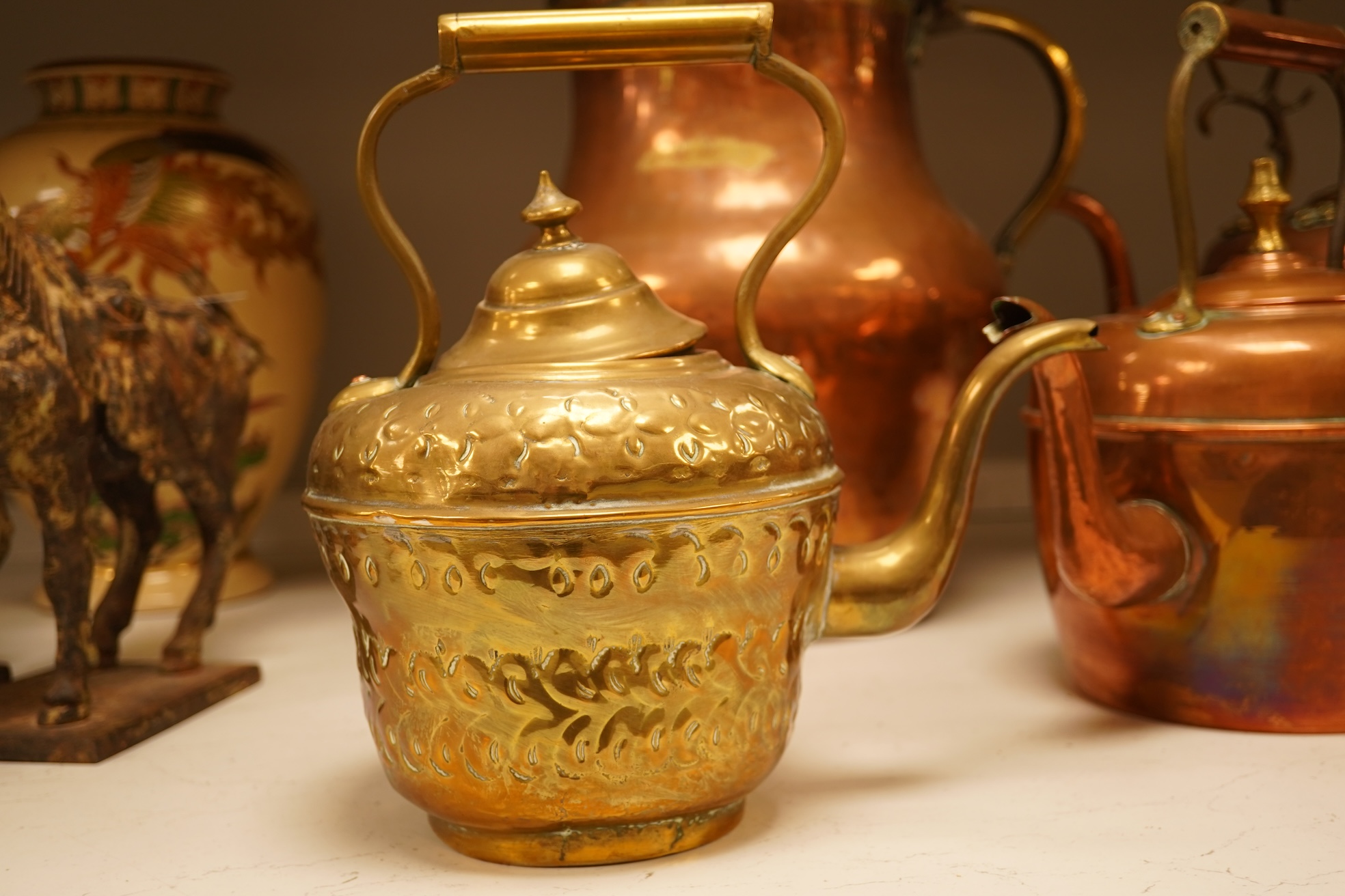 Four various copper vessels and a brass teapot, tallest 47cm